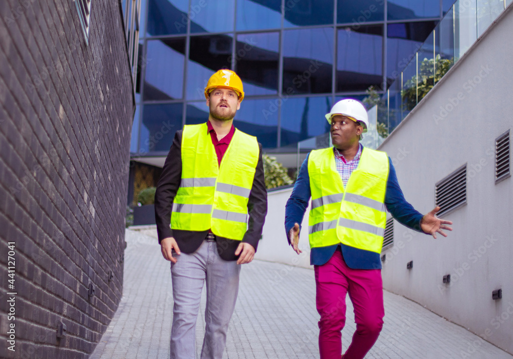 Engineer discussing the structure of the building with architects colleague at construction site. Businessmen talking. Engineer discussing the structure of the building with architects colleague at construction site. Businessmen talking.
