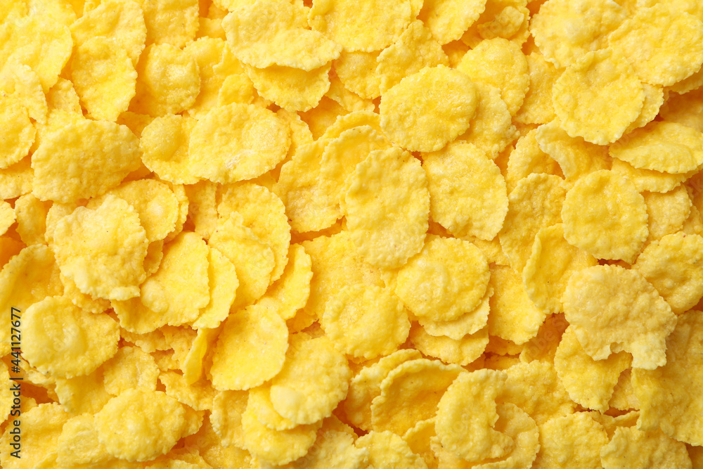Dry uncooked corn flakes on whole background, close up Dry uncooked corn flakes on whole background, close up