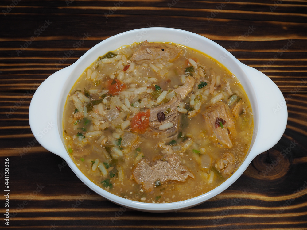 Hot kharcho soup with meat, rice and vegetables, spicy herbs in a white bowl on a wooden table, flat layout. A traditional classic dish for lunch. Rich thick broth with beef, Georgian cuisine Hot kharcho soup with meat, rice and vegetables, spicy herbs in a white bowl on a wooden table, flat layout. A traditional classic dish for lunch. Rich thick broth with beef, Georgian cuisine