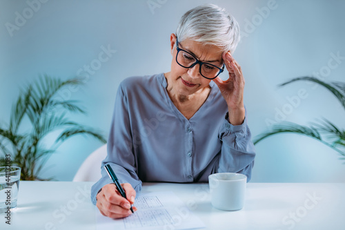 Cognitive Training. Senior Woman Solving Sudoku. photo