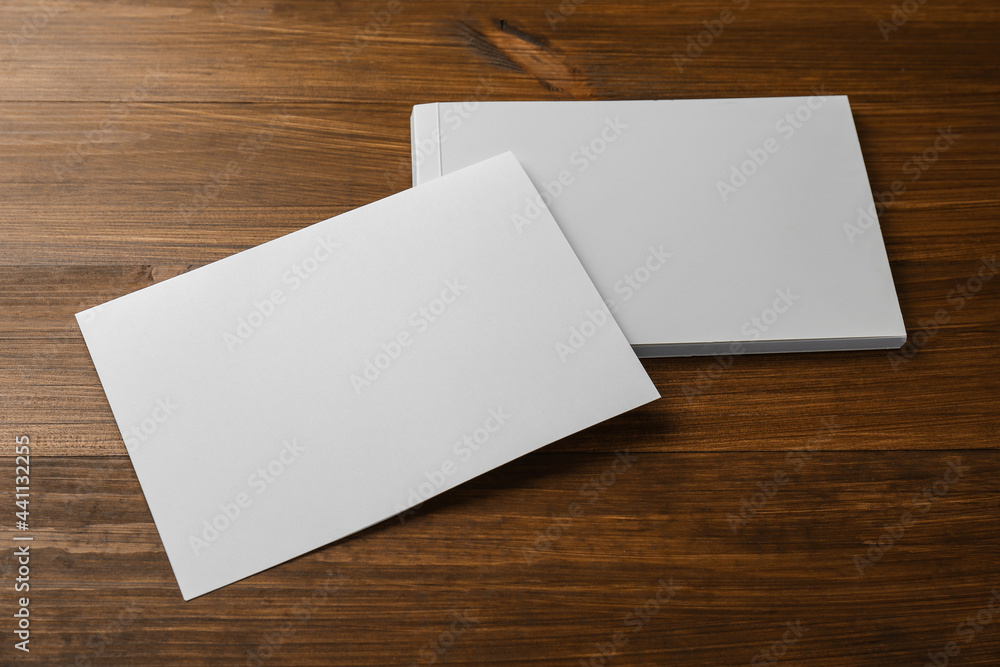Sheet of paper and blank brochure on wooden table. Mockup for design Sheet of paper and blank brochure on wooden table. Mockup for design
