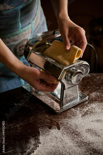 Hands take the dough out of the ravioli machine