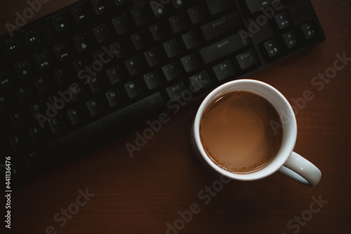 Coffee cup and computer keyboard on work desk. Top view with copy space for your text 