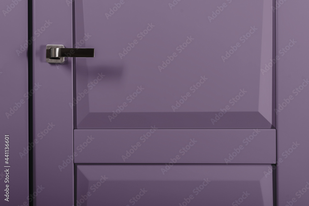 Modern chrome door handle on violet bright door Modern chrome door handle on violet bright door