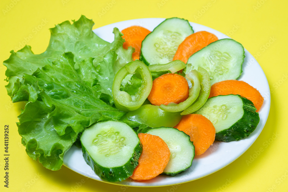 Delicious vegetable salad on a yellow background. Healthy diet food made from fresh vegetables. Vegetarian food Delicious vegetable salad on a yellow background. Healthy diet food made from fresh vegetables. Vegetarian food
