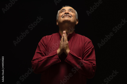 PORTRAIT OF A SENIOR ADULT MAN LOOKING ABOVE AND PRAYING