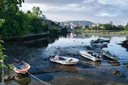 Embarcaciones y lanchas a motor varadas en la desembocadura del río Verdugo durante la marea baja en Ponte Sampaio, Pontevedra, España photo