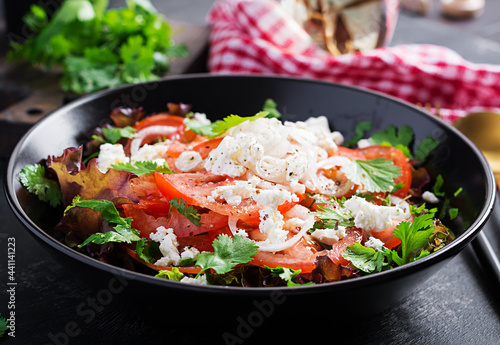 Vegetable salad with tomato, fresh lettuce, soft cheese and onion. Healthy diet food.