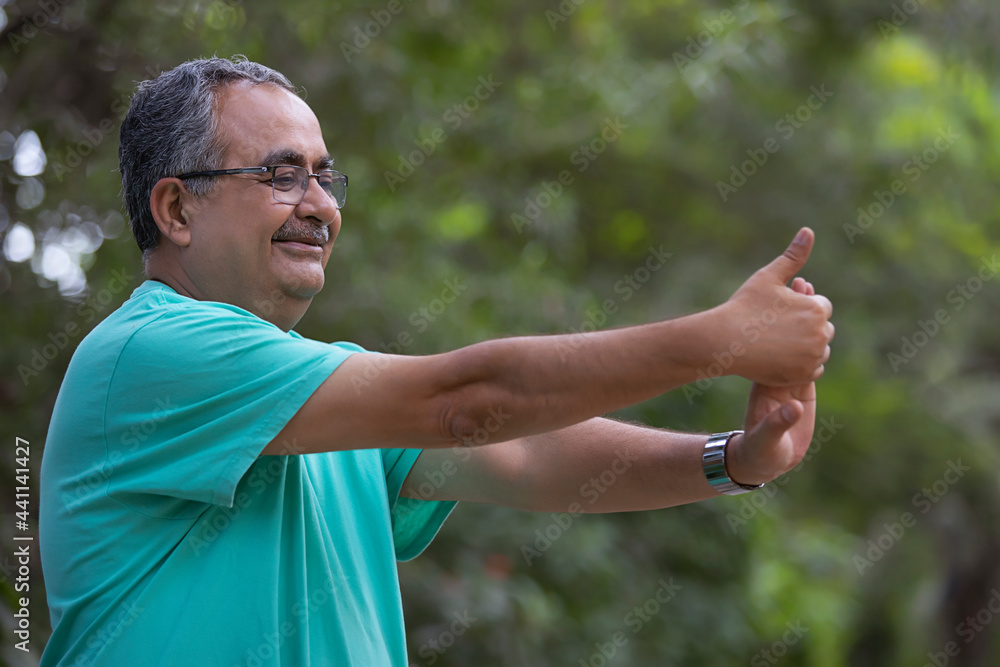 A SENIOR ADULT MAN HAPPILY EXCERCISING IN A PARK A SENIOR ADULT MAN HAPPILY EXCERCISING IN A PARK