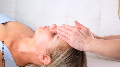 Facial massage beauty treatment. Close up of a young womans face lying on back  getting face lifting massage  pinch and roll technique