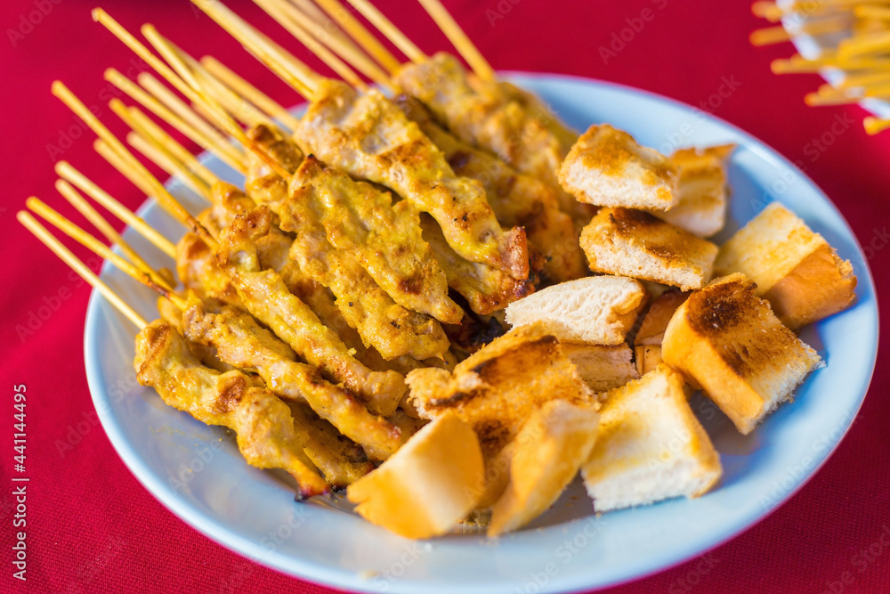 Grilled pork Satay is served with toast,peanut sauce,pickles which are cucumber and onion sliced in vinegar. Grilled pork Satay is served with toast,peanut sauce,pickles which are cucumber and onion sliced in vinegar.