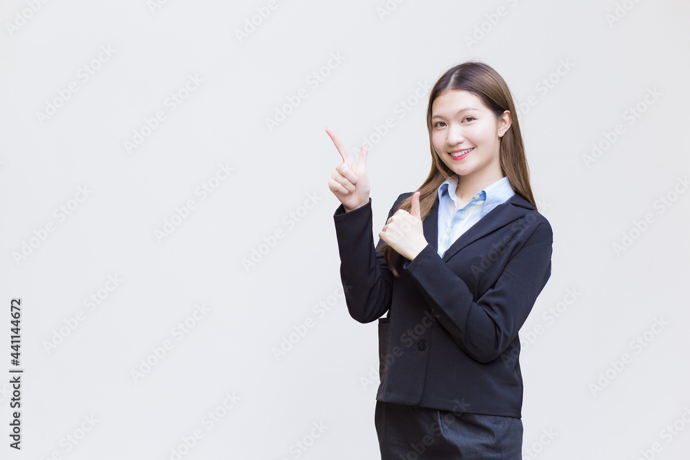 Asian working woman who has long hair wears black formal suit with blue shirt while she shows point up to present something on white background. Asian working woman who has long hair wears black formal suit with blue shirt while she shows point up to present something on white background.