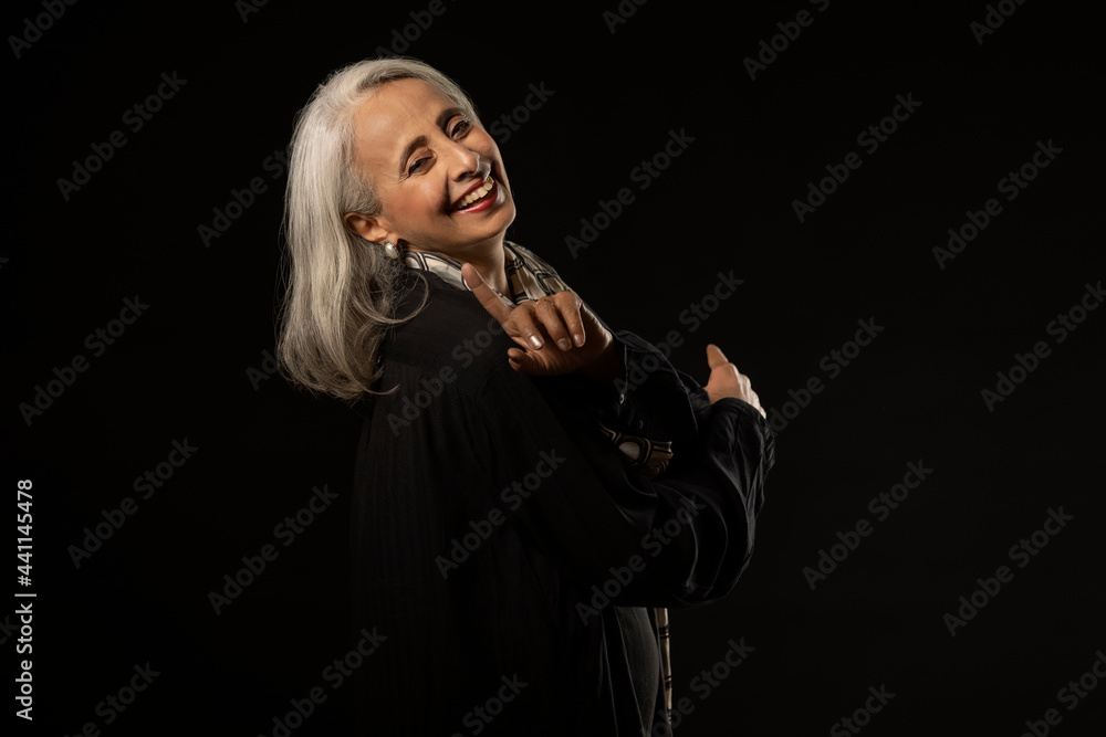 Portrait of an old beautiful woman smiling with a finger raised. Portrait of an old beautiful woman smiling with a finger raised.