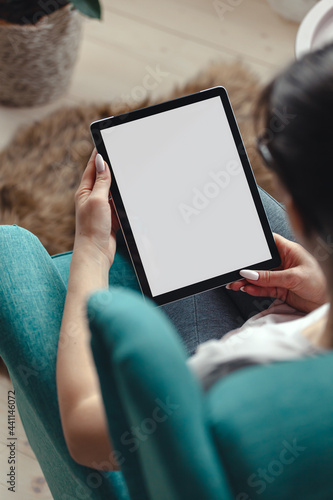 Obraz na płótnie Young woman using digital tablet while sitting in a comfortable