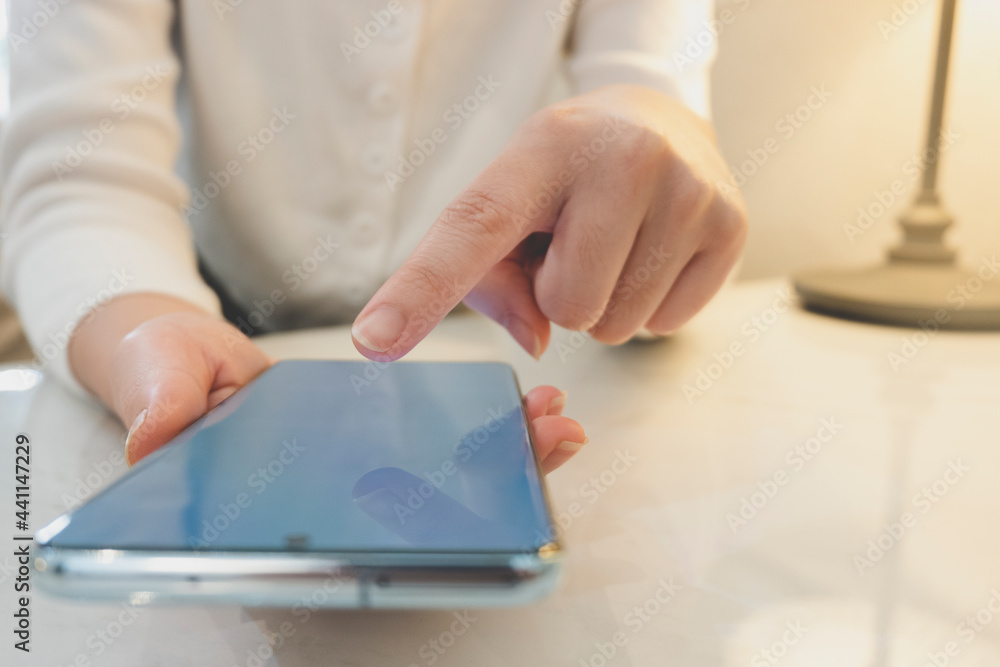 image of a woman sitting and pointing at a white screen phone in a cafe image of a woman sitting and pointing at a white screen phone in a cafe