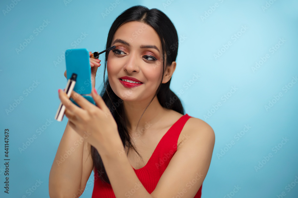 Close-up portrait of young woman applying mascara Close-up portrait of young woman applying mascara