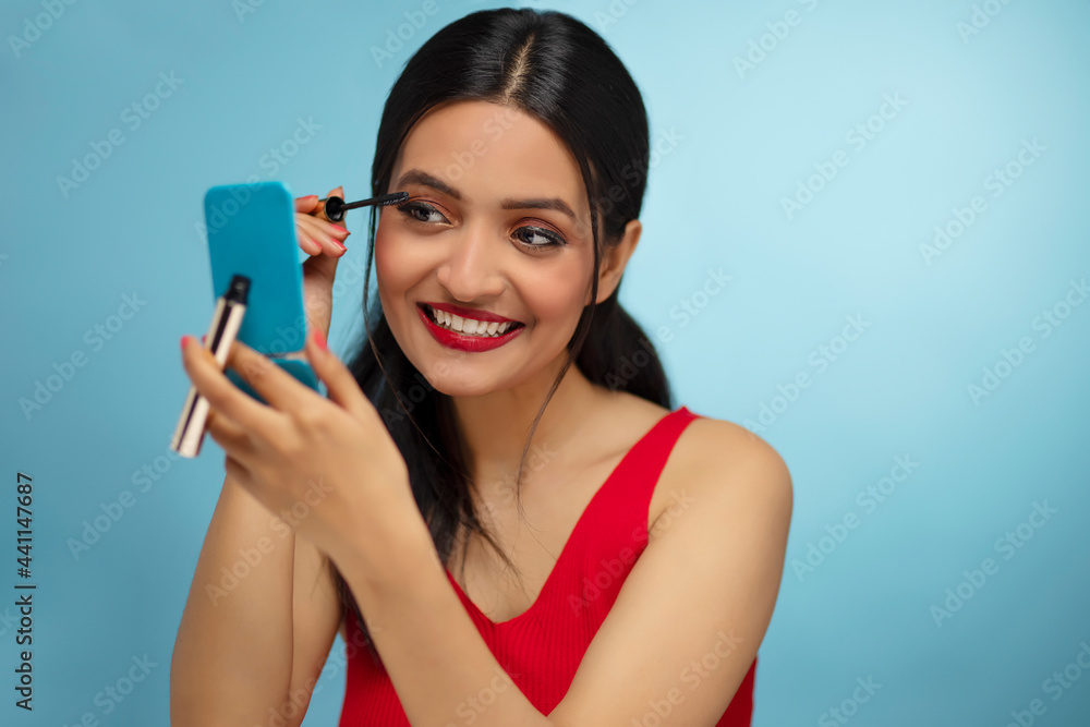 Close-up portrait of young woman applying mascara Close-up portrait of young woman applying mascara