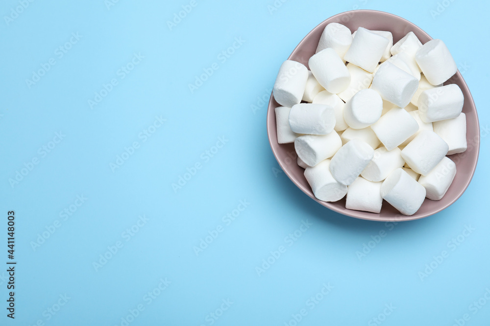 Delicious puffy marshmallows on light blue background, top view. Space for text Delicious puffy marshmallows on light blue background, top view. Space for text