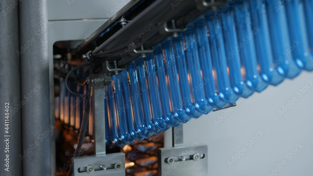 The blue preforms are sent to the blow molding machine. Production of plastic bottles at the mineral water bottling plant The blue preforms are sent to the blow molding machine. Production of plastic bottles at the mineral water bottling plant