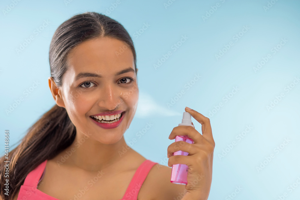 Close Up portrait with Rose Water spraying on Face of young beautiful woman Close Up portrait with Rose Water spraying on Face of young beautiful woman