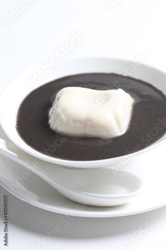chef cook thick black sesame sweet soup with soya milk pudding jelly in white bowl Chinese traditional dessert menu
