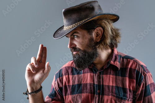 Portrait of cowboy in hat. Portrait of man wearing cowboy hat, gun. Portrait of a cowboy. West, guns. Portrait of a cowboy. American bandit in mask, western man with hat