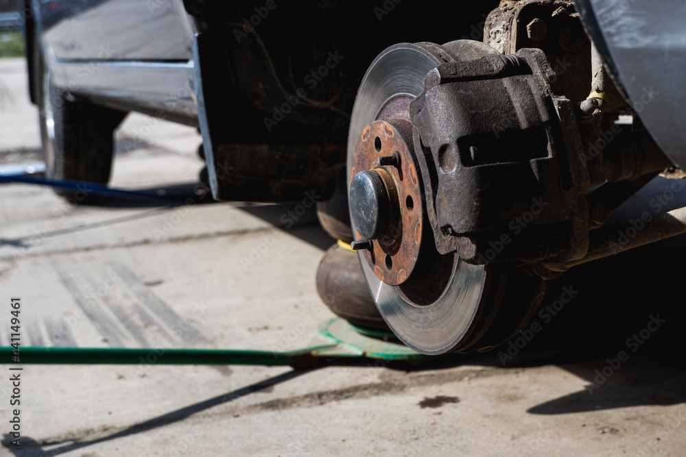Car repair. Car with removed wheels on pneumatic jacks. View of the brake discs hub. Car repair. Car with removed wheels on pneumatic jacks. View of the brake discs hub.