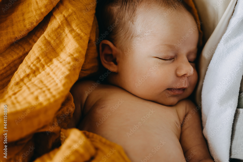 Closeup of a newborn baby dreaming and smiling while sleeping. - obrazy, fototapety, plakaty 