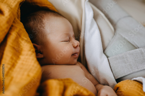 Closeup of a newborn baby dreaming and smiling while sleeping.