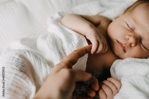 Obraz na plátně Closeup of a newborn baby holding mother's finger.