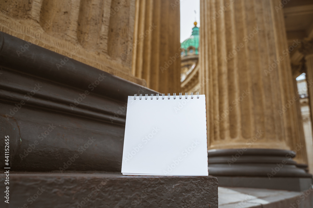 Blank paper notebook for copy space on the background of the columns of the Kazan Cathedral in St. Petersburg, education in Russia