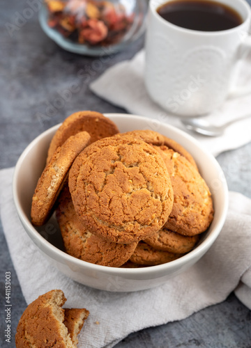 Homemade oat cookies in a bowl with a cup of coffee