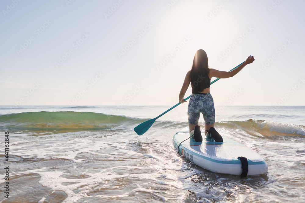 Girl paddling on a paddle board at sunrise Girl paddling on a paddle board at sunrise