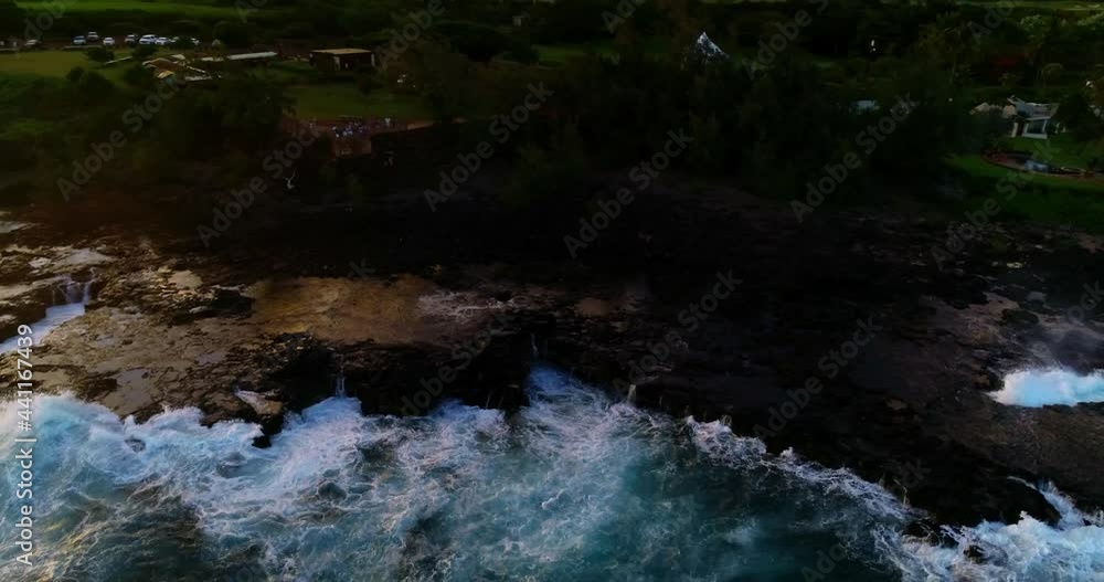 Aerial Panning Shot Of People Looking At Waves Splashing In Sea At Sunset During Vacation - Kauai, Hawaii Aerial Panning Shot Of People Looking At Waves Splashing In Sea At Sunset During Vacation - Kauai, Hawaii