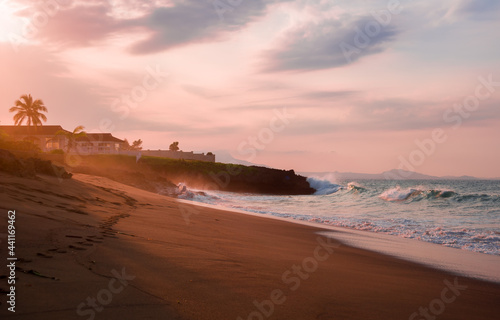 house villa on yje cost brutal waves romantically crash on terracotta rocks at sunset on a Caribbean island on the coast of the Atlantic Ocean