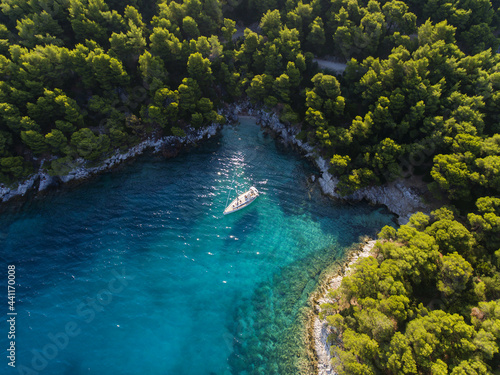 Aerial view of a sailboat anchored at Cape Amarandos near Aghnondas in the Greek island of Skopelos in the Northern Sporades