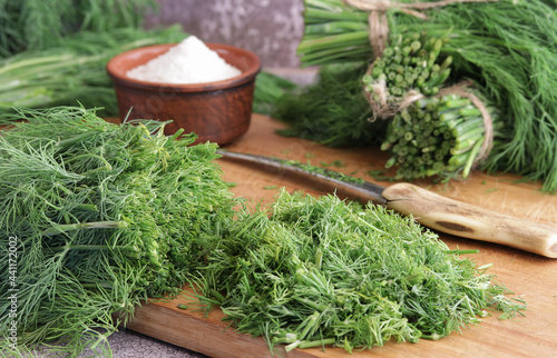 The process of preparing fresh green dill with salt for storage for the winter.