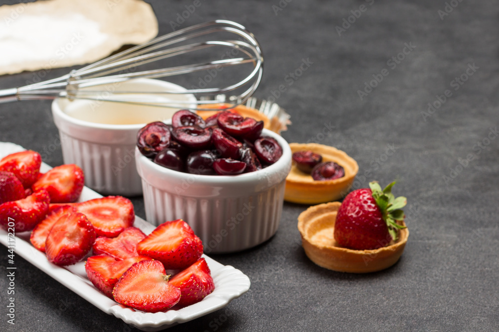 Berries on plate and in tartlets. Whisk on bowl Berries on plate and in tartlets. Whisk on bowl