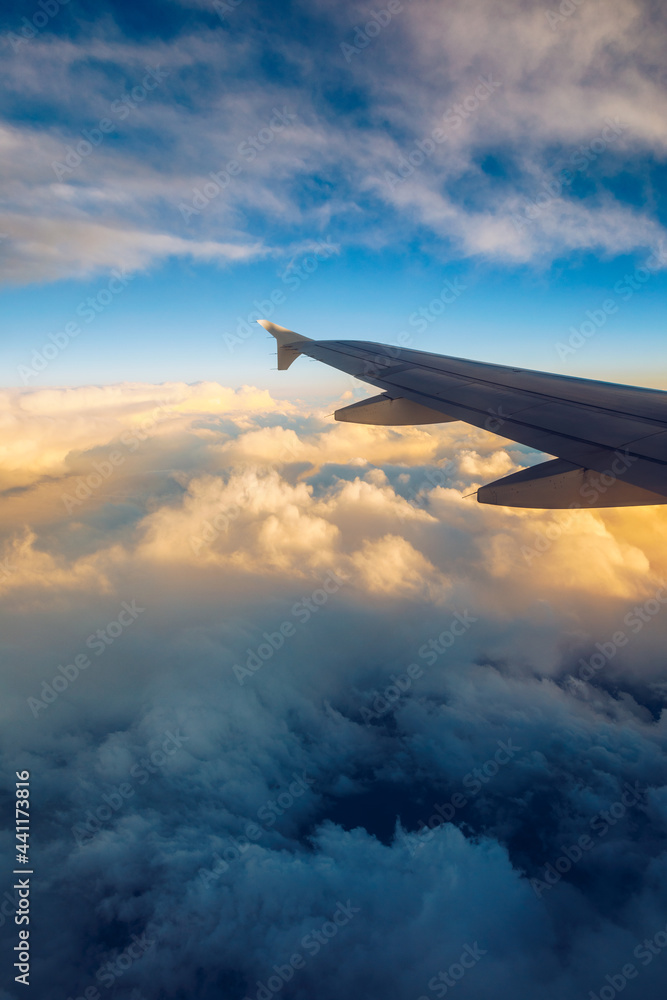 Flying and traveling, view from airplane window on the wing on sunset time. Aircraft wing under the earth and clouds. Flight in sky. Looking over aircraft wing in flight. Flying and traveling, view from airplane window on the wing on sunset time. Aircraft wing under the earth and clouds. Flight in sky. Looking over aircraft wing in flight.