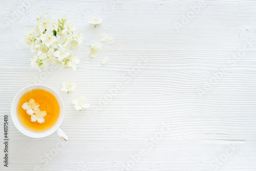 Tea in a cup with jasmine flowers. Herbal tea top view