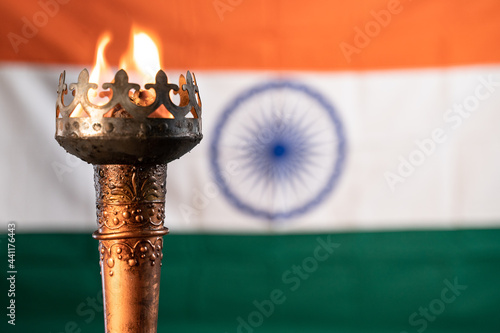 Close up of burning flame on sports torch realy with Indian as background photo