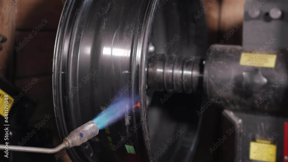 Alloy wheel being heated on straightening stand