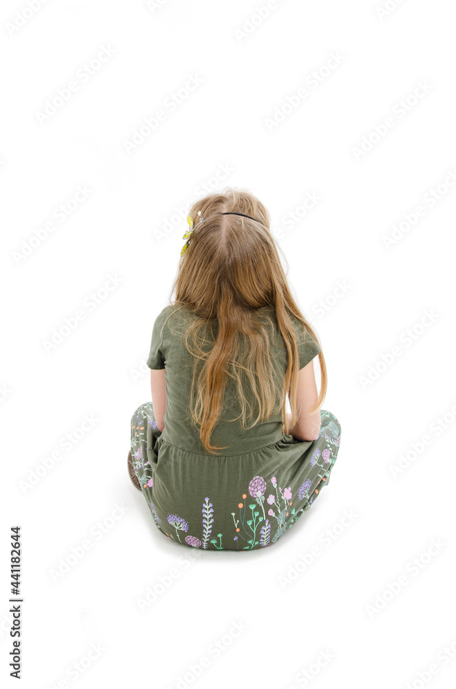Rear view of little girl sitting on floor looking up. Isolated on white ...