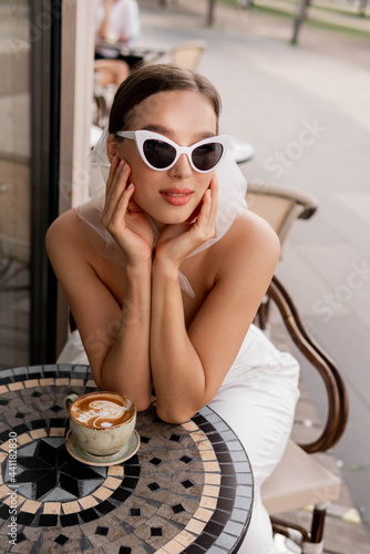 Summer fashion look. Woman in a white suit and retro sunglasse. Close-up portrait