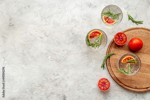 Glasses of cold drink with red oranges and rosemary