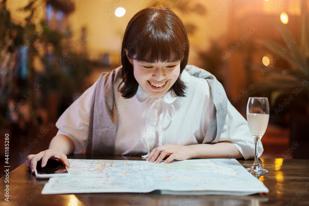 おしゃれな空間で、地図を見る若い女性 おしゃれな空間で、地図を見る若い女性