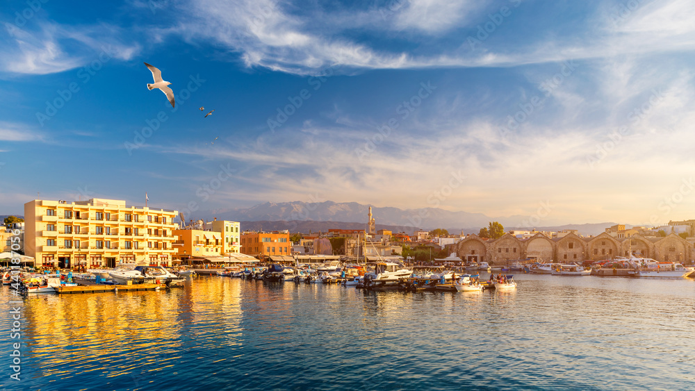 Old port of Chania with flying seagulls. Landmarks of Crete island. Bay of Chania at sunny summer day, Crete Greece. View of the old port of Chania, Crete, Greece. The port of chania, or Hania.