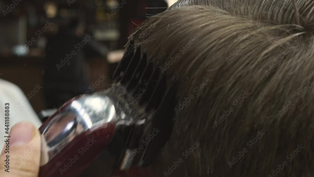Male haircut with electric razor. Close up of hair trimmer hairstyle. Barber makes haircut for client at the barber shop by using hairclipper. Man hairdressing with electric shaver. Handheld shot. 4K. Male haircut with electric razor. Close up of hair trimmer hairstyle. Barber makes haircut for client at the barber shop by using hairclipper. Man hairdressing with electric shaver. Handheld shot. 4K.