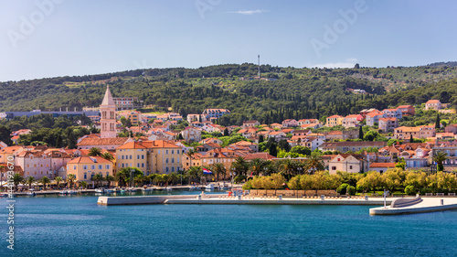 Supetar city in Brac island, Croatia. View from the sea. Picturesque scenic view on Supetar on Brac island, Croatia. Panoramic view on harbor of town Supetar from the side of sea. Brac, Croatia. photo