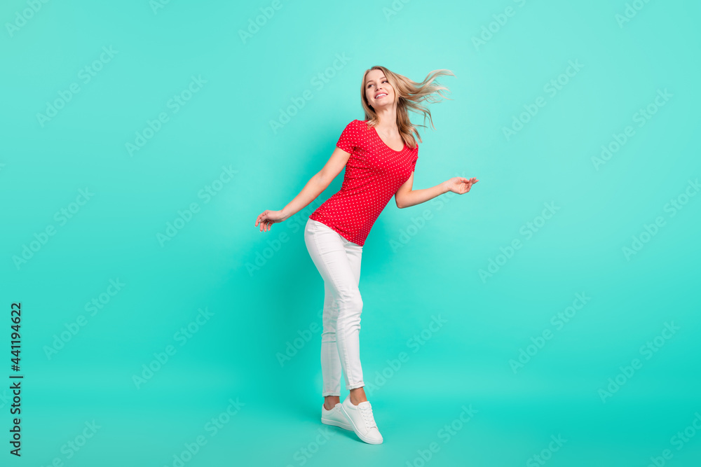 Full body profile side photo of young woman happy positive smile dream think look empty space isolated over teal color background Full body profile side photo of young woman happy positive smile dream think look empty space isolated over teal color background